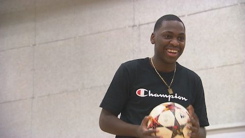 Le joueur de soccer Daniel Kinumbe avec un ballon dans les mains. 
