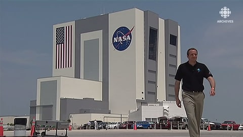 David Saint-Jacques se tient devant les bâtiments de la NASA à Houston au Texas. 
