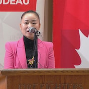 La candidate du Parti libéral Karen Wang donne un discours debout devant un microphone.
