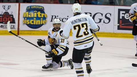 Deux joueurs des Tigres de Victoriaville célèbrent sur la patinoire après un but.