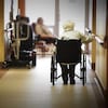 Une dame dans un fauteuil roulant dans le couloir d'un CHSLD