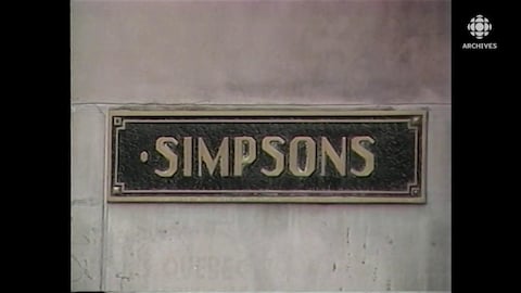 Plaque de métal avec le nom Simpsons encastrée sur l'édifice Simpson de la rue Sainte-Catherine, à Montréal.