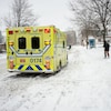 Un ambulance sur le bord d'une rue enneigée de Montréal.