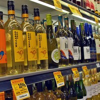 Des rangées de bouteilles de vin dans une épicerie