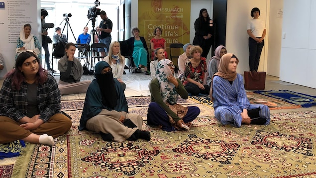 On voit quelques musulmanes du quartier assises sur des tapis orientaux.
