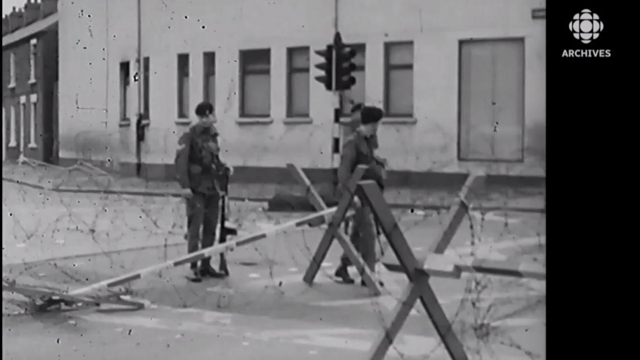 Trois soldats britanniques installent un barrage de barbelés dans une rue de Derry, en Irlande du Nord. 