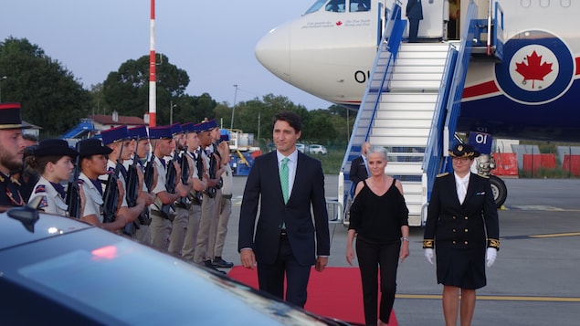 Justin Trudeau marche sur un tapis rouge à sa descente de l'avion. 