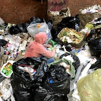 Une adolescente trie les déchets à mains nues dans le bidonville de Manshiyat Nasser.