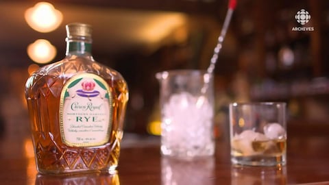 Bouteille de whisky canadien Crown Royal avec un verre et un seau de glace.