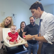 Justin Trudeau devant un bébé qui pleure sur une balance.