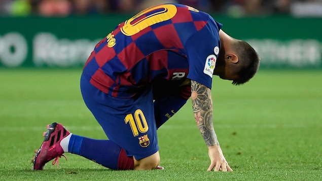 Messi pose le genou droit sur le terrain et se tient le gauche