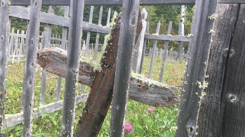 Une croix de bois entourée d'une clôture de bois.