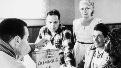 Une photo en noir et blanc de personnes qui votent dans les années 60.
