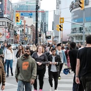 Des passants marchent dans la rue à Toronto.
