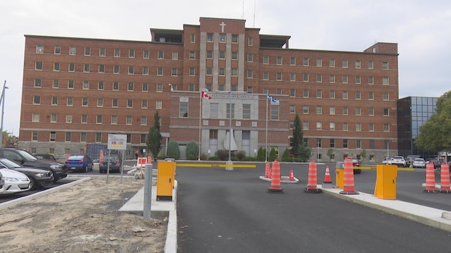Drapeau du Québec et drapeau du Canada devant un hôpital.
