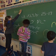 Des élèves écrivent au tableau en inuktitut.