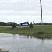 Pancarte du village de La Broquerie entourée d'eau
