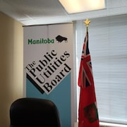Une bannière au bureau de la Régie des services publics du Manitoba.