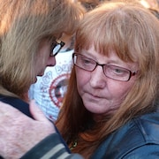 Une femme en pleurs est consolée par une proche.