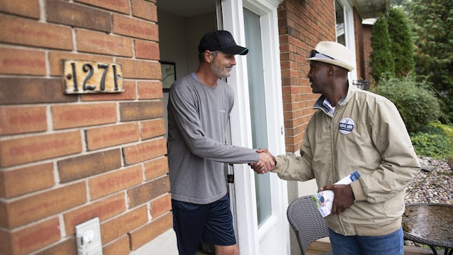 Abdul Abdi, Conservative candidate for Ottawa West-Nepean, shakes hands with a resident as he goes campaigning door to door in Ottawa on Saturday, Sept. 28, 2019. THE CANADIAN PRESS/Justin Tang 