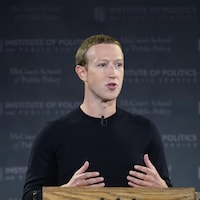 Mark Zuckerberg, debout derrière un lutrin en bois, s'adresse à une foule.