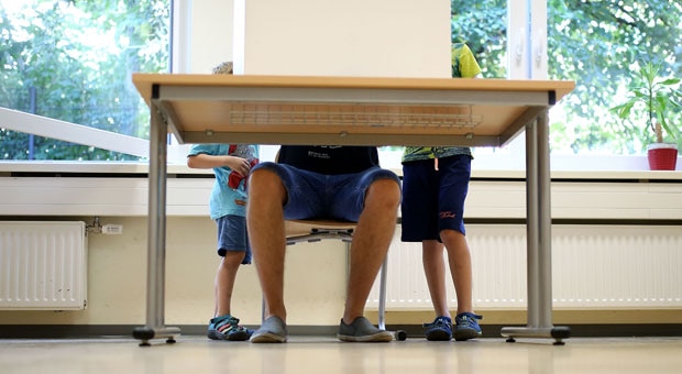 two young boys accompany their dad to vote in an election
