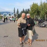 Raymon Bisson et Lorrain Bisson sourient devant les anneaux olympiques. 