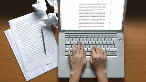 Une personne rédigeant un texte à l'ordinateur
