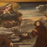 Un homme agenouillé devant la Vierge. Deux hommes sont morts, étendus au sol dans un paysage hivernal.