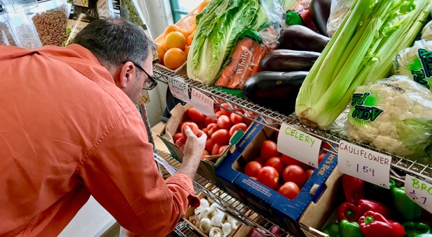 a dad shops the fresh produce section of a grocery store