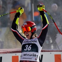 Portant ses lunettes et son casque, la skieuse Marie-Michèle Gagnon lève les bras pour célébrer après sa descente. 