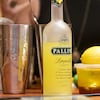 Des bouteilles d'alcool, un citron, un pichet de glace et autres préparations servant à faire des cocktails.