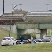 Les wagons sont penchés sur un pont qui traverse la route.