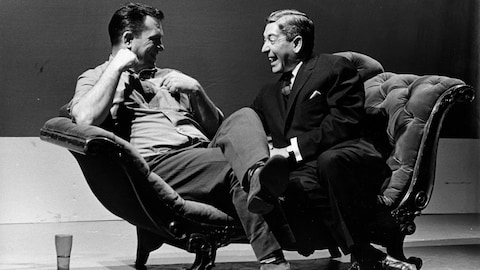 Jack Kerouac et Fernand Séguin qui rigolent assis sur un divan.