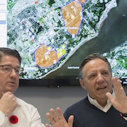 Le premier ministre Francois Legault et le PDG d'Hydro-Québec Eric Martel devant une carte du Québec indiquant les pannes.