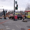 Des ambulances sont stationnées devant un abribus détruit, sur le coin d'une rue.