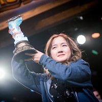 Une femme tient un trophée après avoir remporté une compétition au BlizzCon 2019.