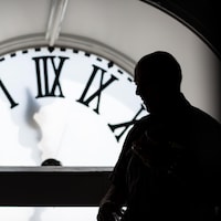L'horloger André Viger est photographié à contre-jour, dans la tour-horloge de l'Assemblée nationale du Québec.