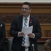 Un homme en veston à l'Assemblée législative de l'Ontario. 