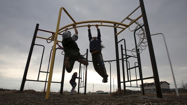 Des enfants jouent dans un parc situé dans la communauté d'Attawapiskat, dans le nord de l'Ontario.
