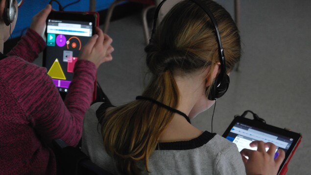 Des jeunes explorent une application sur une tablette.