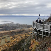 Quelques personnes sont sur l'un des belvédères de bois qui surplombe Carleton, au sommet du mont Saint-Joseph. Au loin, la baie des Chaleurs.