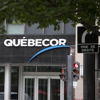 L'enseigne de Québecor derrière un panneau où il est écrit « voie de droite ».
