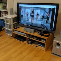 Une femme installe une vidéo de remise en forme sur son ordinateur, qui est connecté à un écran de télévision.