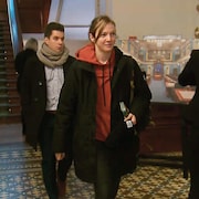 Catherine Dorion porte un coton ouaté rouge qu'on aperçoit sous un manteau noir. 
