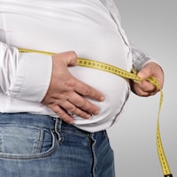 Un homme obèse mesure son tour de taille.