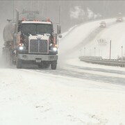Un véhicule lourd circule sur la route 138 pendant une tempête de neige, le 12 novembre 2019.