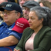 Des personnes assises avec des casquettes Make Alberta Great Again et Wexit dans une école de Calgary pendant un rassemblement du mouvement Wexit.