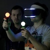 Un homme joue à un jeu en réalité virtuelle avec des manettes contrôlées par le mouvement. 