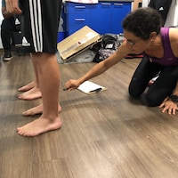 Anne-Laure Ménard, étudiante au postdoctorat en biomécanique, mesure les pieds de deux jeunes joueurs de soccer dans le cadre d'une étude.